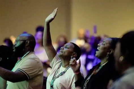 Believers worshiping together with hands raised